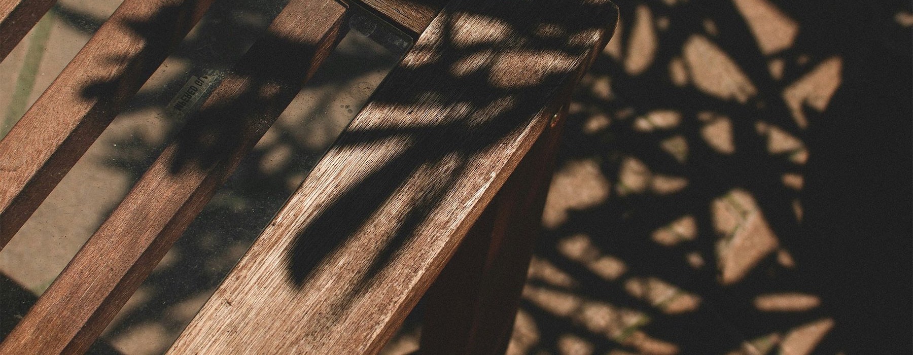a wooden chair with shadows of leaves